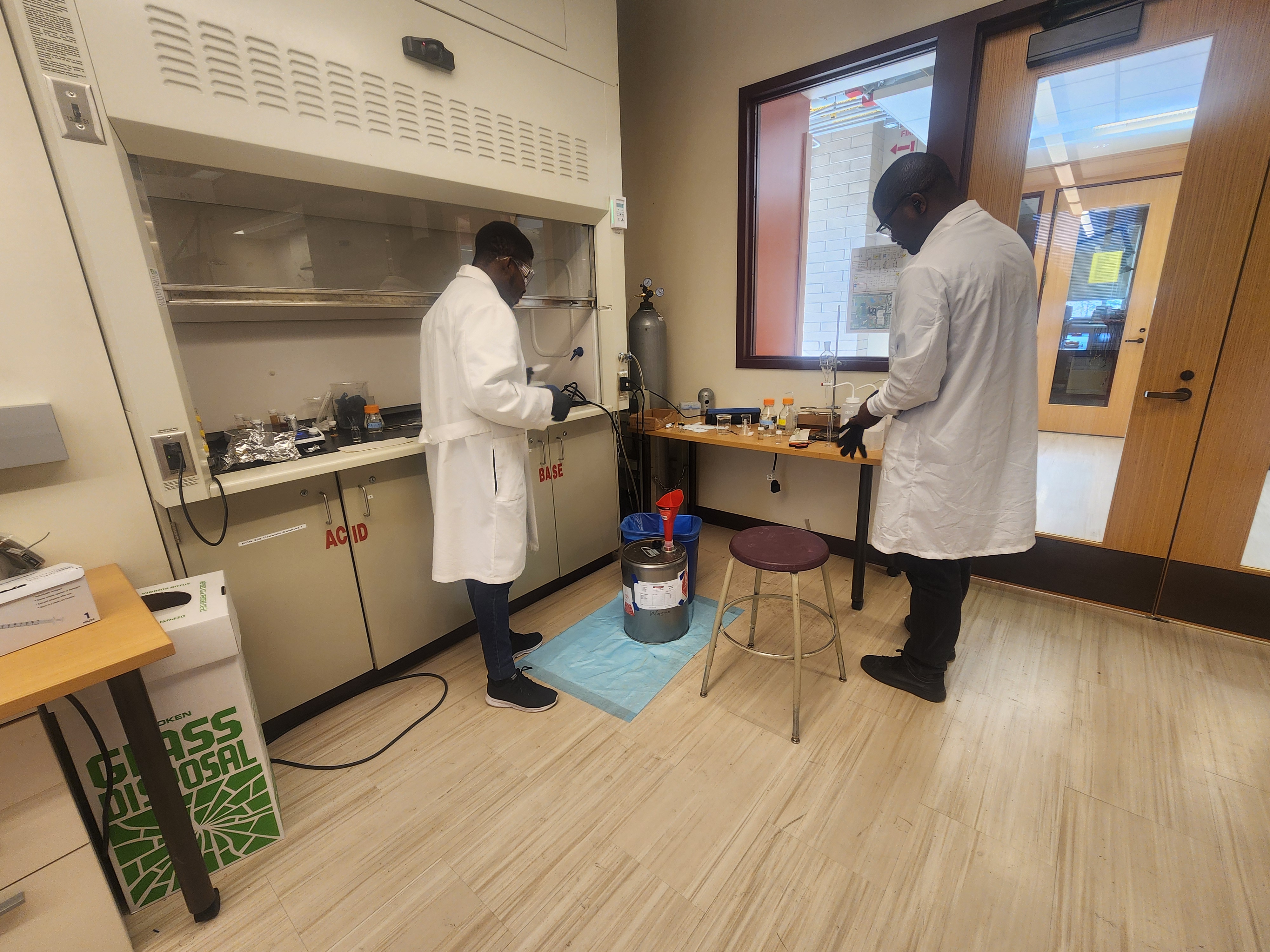 Two researchers in lab coats standing in Kumar's lab