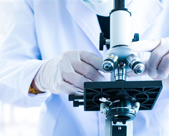 A researcher works with a microscope.