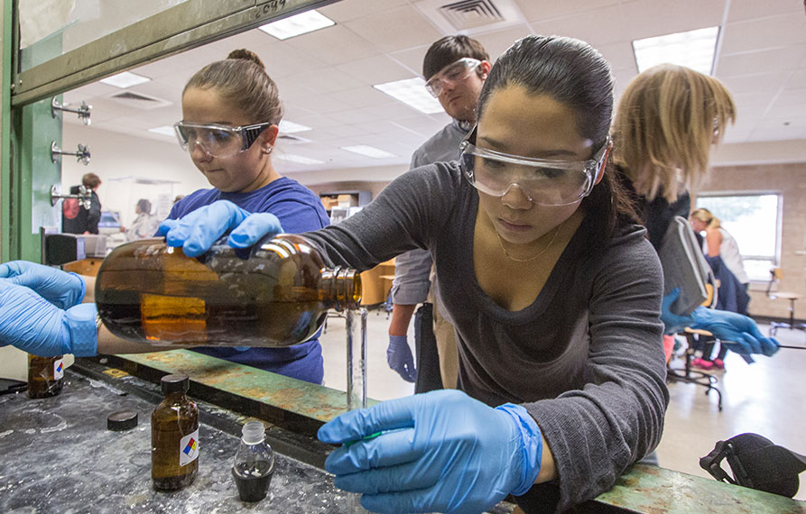 undergraduate student working under chemistry lab hood