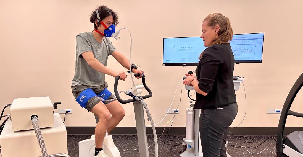 Student and professor using exercise bike and medical monitoring equipment