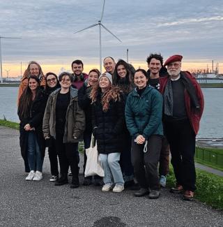 Students pose for a group photo by a string of windmills in the Netherlands.