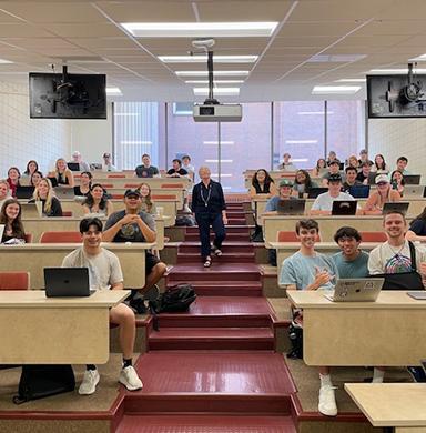 Nancy Sasaki stands in the classroom with her students.