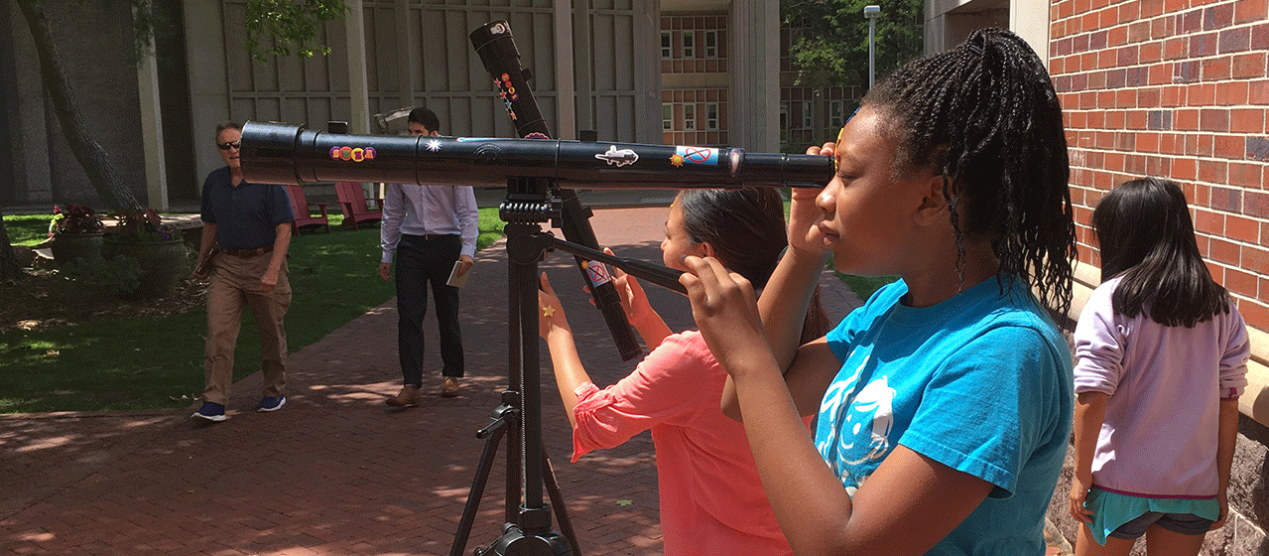 campers learning how to operate telescopes